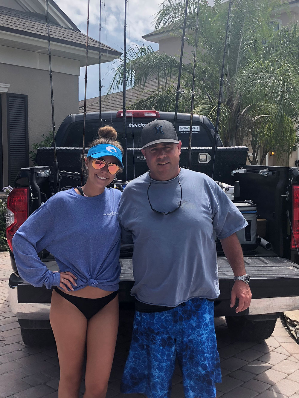 Hailee Worth and Chris Worth standing next to each other in front of fishing rods in a pick up truck