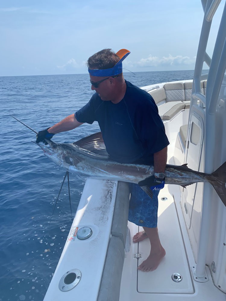 Chris Worth bringing in a marlin on to the boat